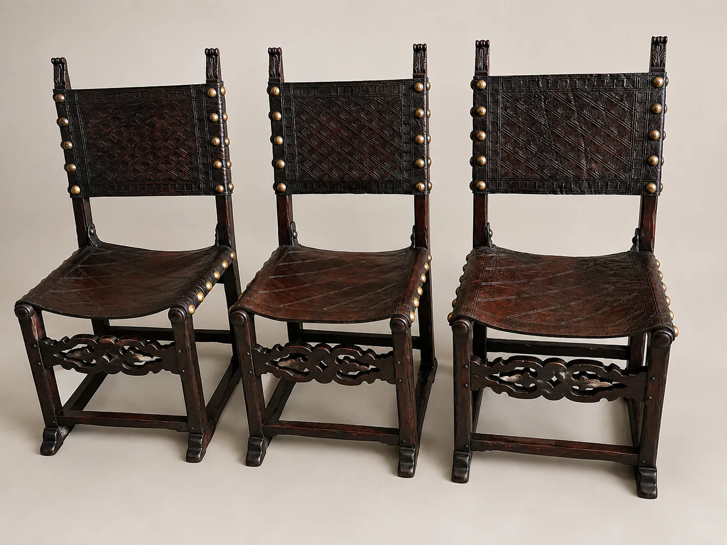 Trois chaises espagnoles Frailero fin XIXe – début XXe en bois massif et cuir repoussé