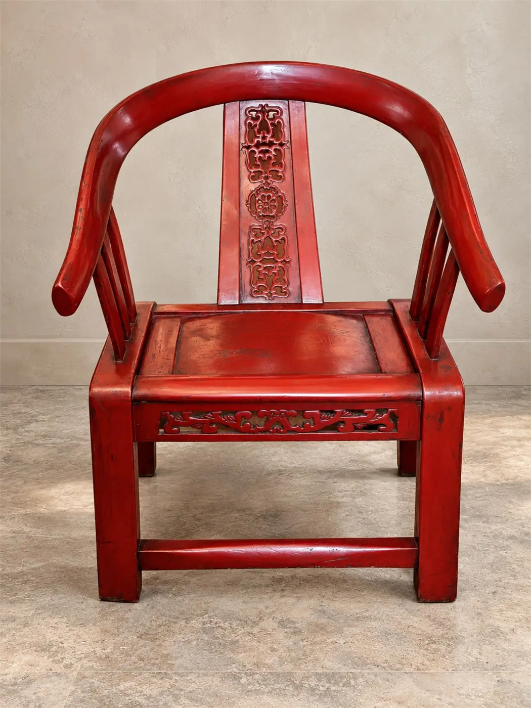 Fauteuil chinois en bois rouge patiné à dossier fer à cheval